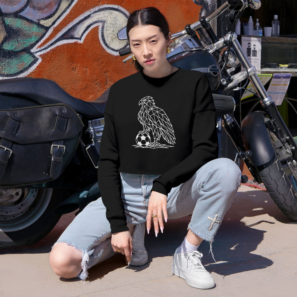 Person wearing a black sweatshirt with an eagle design, sitting in front of a motorcycle.