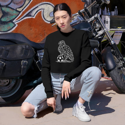 Person wearing a black sweatshirt with an eagle design, sitting in front of a motorcycle.